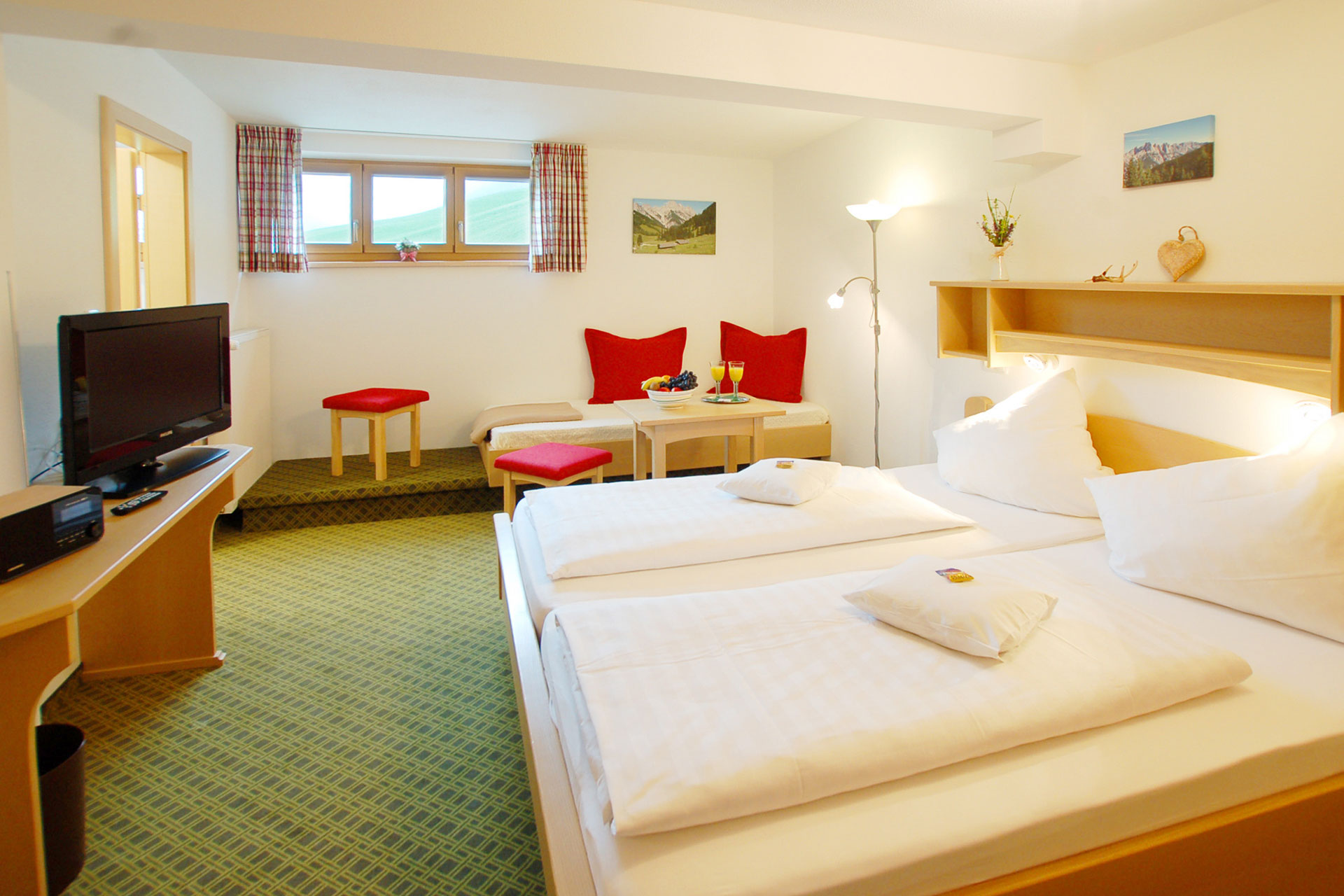 Nichtraucherzimmer mit heimischer Holzeinrichtung, Teppichboden und Podestfenster mit Ausblick ins Klausbachtal im Wörndlhof Ramsau.